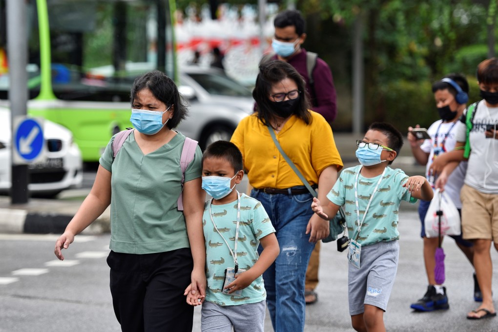 People wearing face masks cross a road in Singapore on Friday. Photo: Reuters