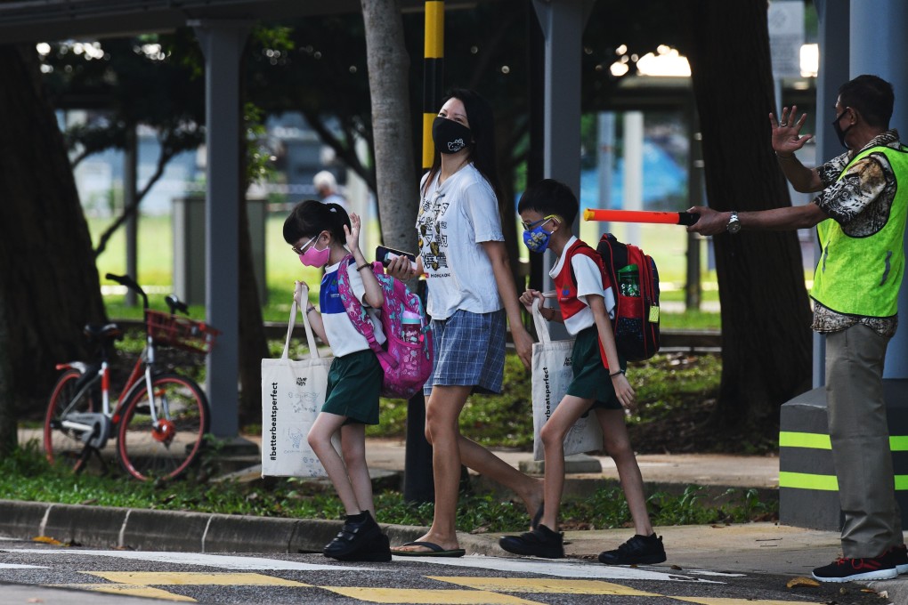 Primary school students wearing face masks make their way to school in Singapore. Photo: Xinhua