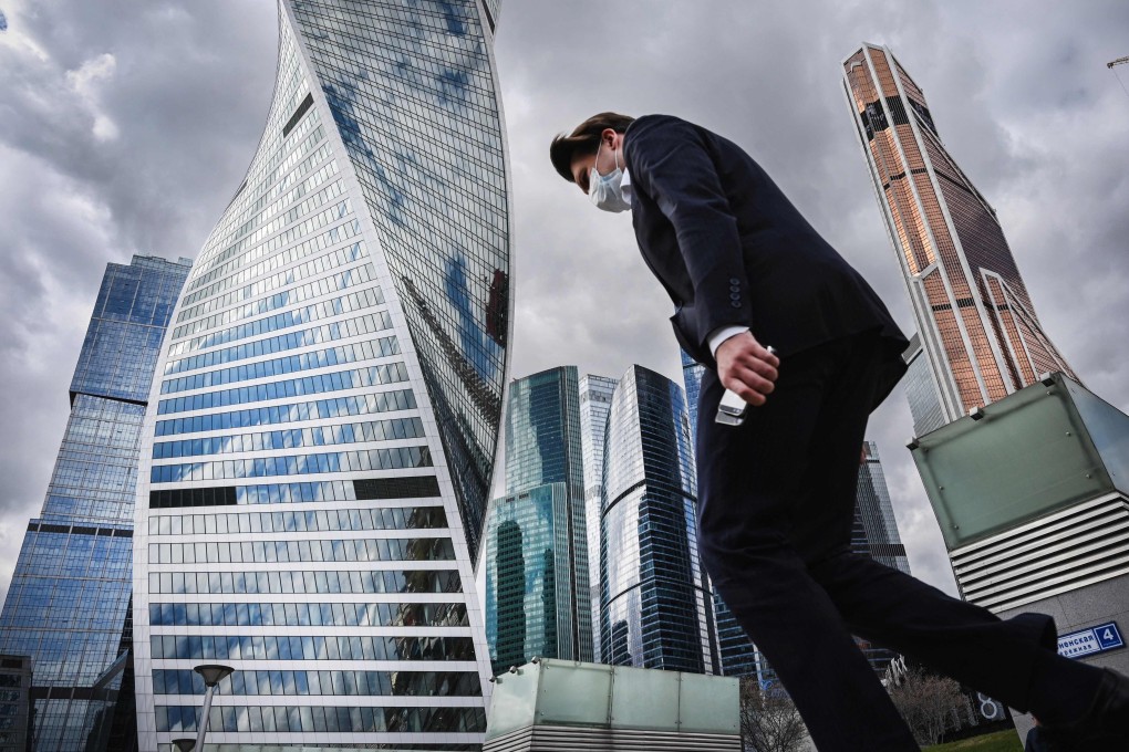 A clerk wearing a face mask walks in Moscow's International Business Centre (Moskva City) in Moscow. Photo: AFP