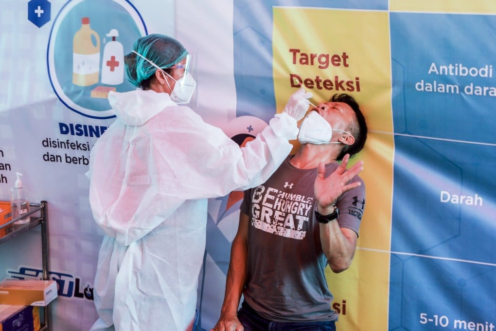 A man reacts as a health care worker collects a swab sample for Covid-19 testing in Medan, Indonesia’s North Sumatra, on Monday. Photo: EPA
