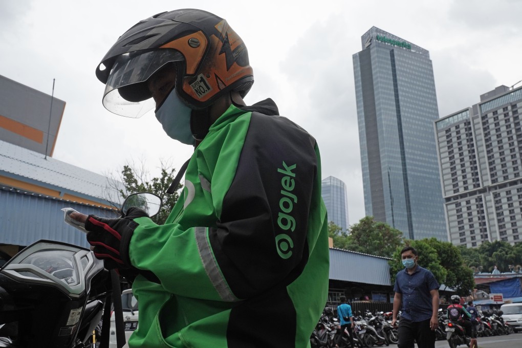 A Gojek driver checks his mobile phone in Jakarta in January. Southeast Asia technology companies Gojek and Tokopedia plan to combine in the biggest merger ever in Indonesia. Photo: Bloomberg