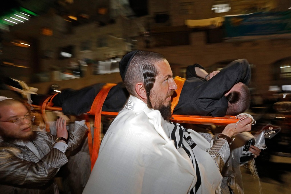 Ultra-Orthodox Jewish men evacuate an injured man after the collapse of grandstand seating at a synagogue in the Israeli settlement of Givat Zeev in the occupied West Bank outside Jerusalem on Sunday. Photo: AFP