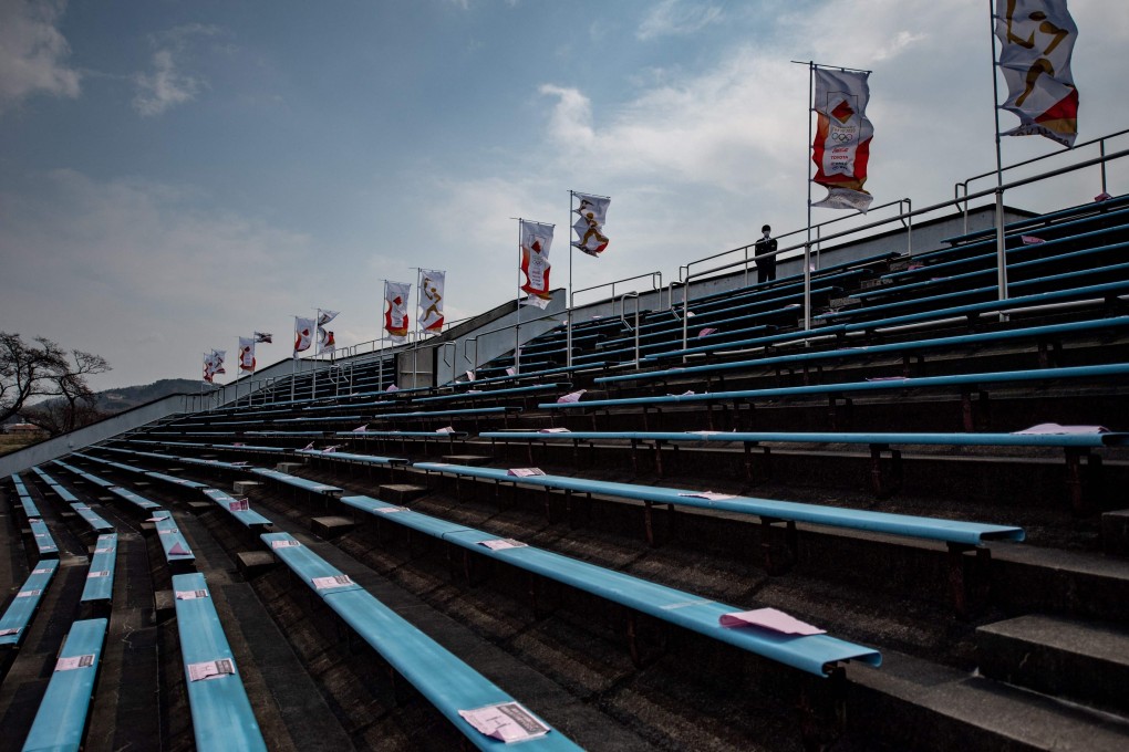 Social distancing signs are pictured on grandstand seats during a ceremony on the second day of the Tokyo 2020 Olympic Games torch relay at Shinobugaoka Stadium in Fukushima on March 26, 2021. Photo: AFP