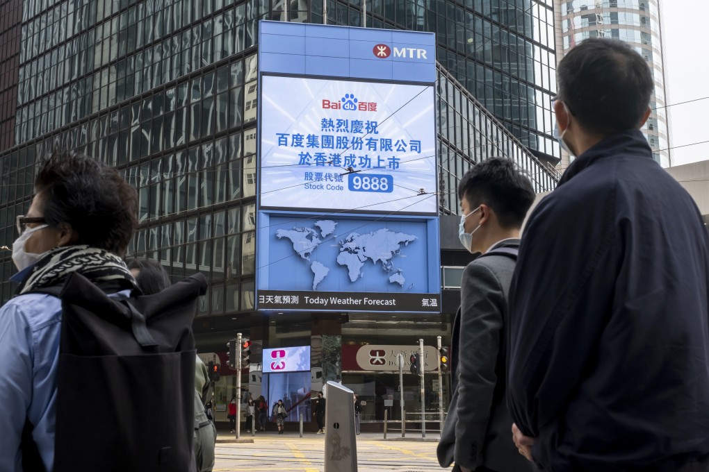 Pedestrians stand in front of a screen showing a message marking the listing of Baidu Inc. on the Hong Kong Stocks Exchange in Hong Kong on March 23, 2021. Photo: Bloomberg