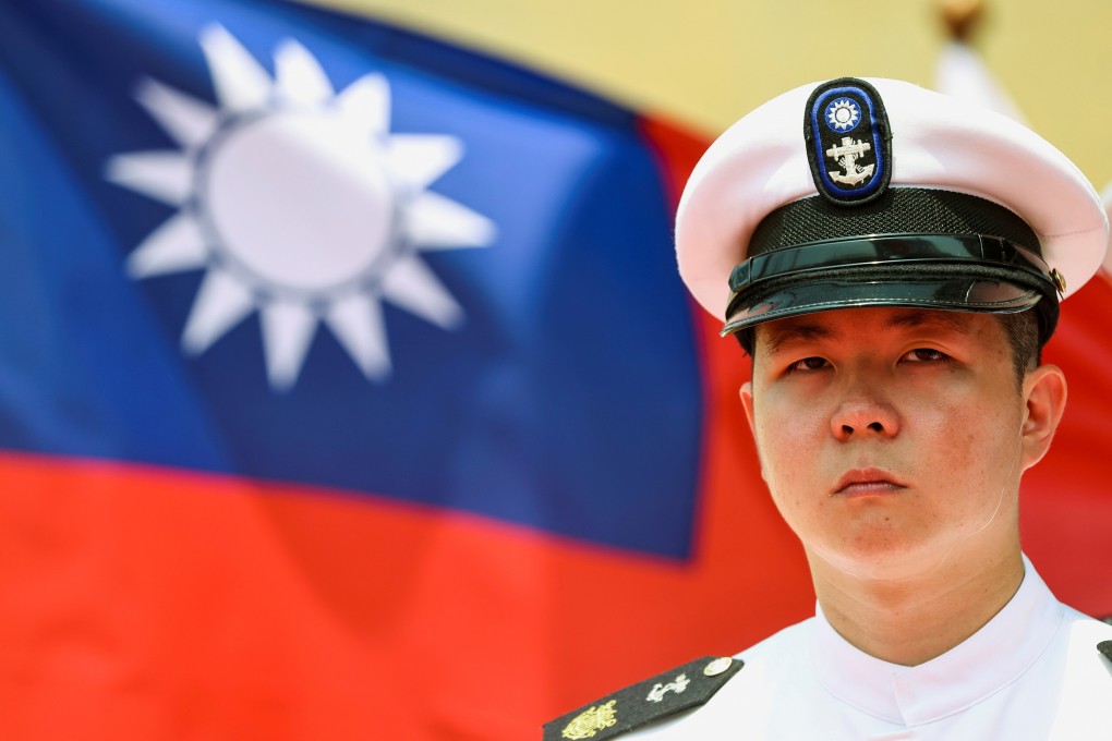 A Taiwan navy honour guard stands in front of a Taiwanese flag during the launch ceremony for a Taiwanese built amphibious transport dock in Kaohsiung, Taiwan, on April 13. Photo: Reuters