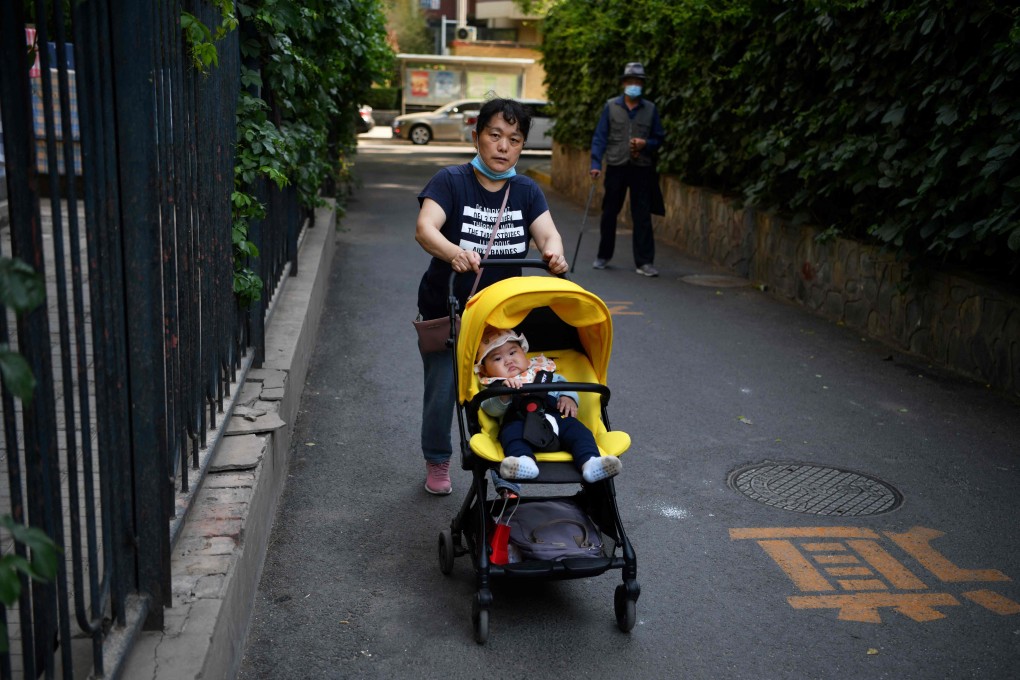 A woman pushes a baby on a stroller along an alley in Beijing on May 12. China should take reference of other societies’ efforts to raise the birth rate. Photo: AFP