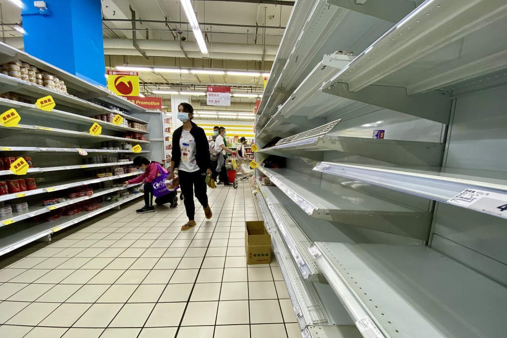 Shoppers check almost empty shelves as they rush to buy grocery essentials in a supermarket in Taipei on May 17. Photo: EPA-EFE