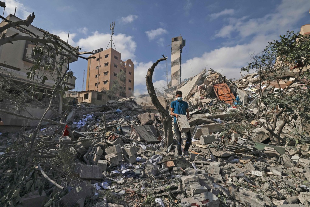 A Palestinian youth looks for salvageable items amid the rubble of the Kuhail building, which was destroyed in an early morning Israeli air strike on Gaza City on Tuesday. Photo: AFP