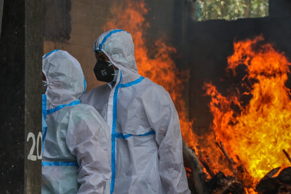 Indian relatives clad in PPE mourn at a cremation ground in New Delhi. Photo: EPA-EFE
