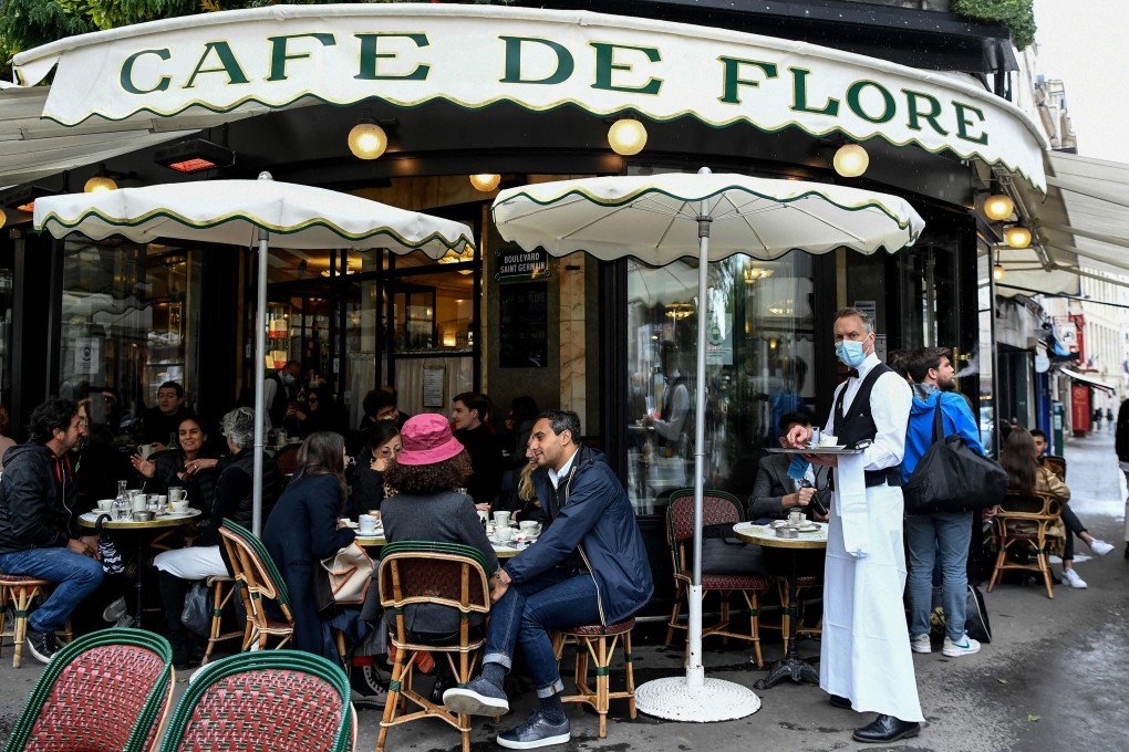 People sit at the terrace of Paris’ landmark Cafe de Flore on Wednesday. Photo: AFP