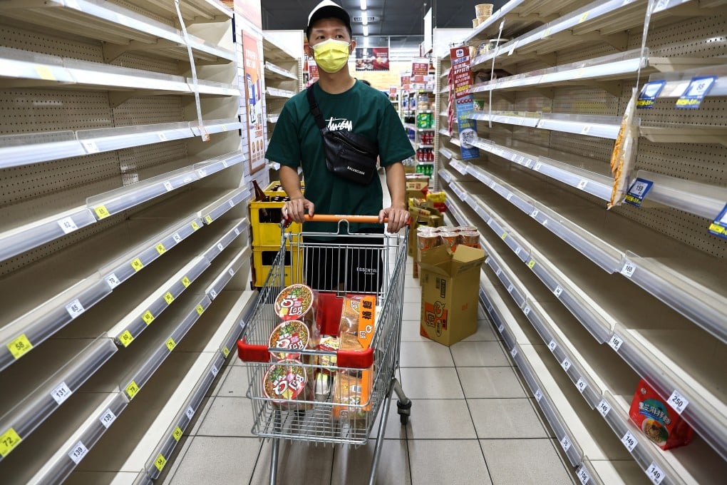A person shops for groceries among near-empty shelves at a store in Taipei on May 17, following a surge in Covid-19 cases in Taiwan. Photo: Reuters