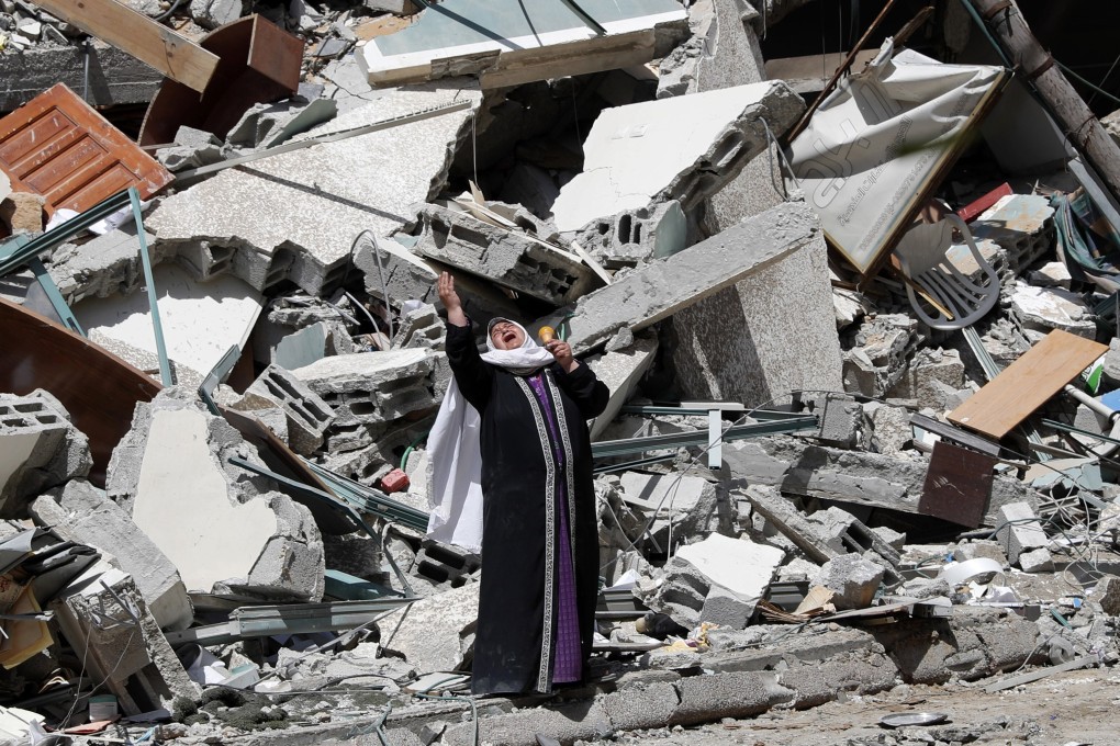 A woman reacts while standing near the rubble of a building that was destroyed by an Israeli air strike in Gaza City. Photo: AP