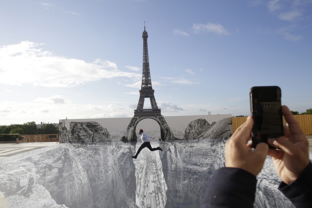 A man jumps at Trocadero square in front of the Eiffel Tower on Wednesday, where a French artist known as JR set his artwork. Photo: AP