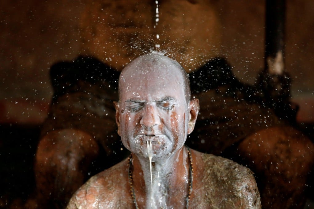 A man bathes in milk to remove cow dung from his body as part of ‘therapy’ some believe boosts immunity at a cow shelter on the outskirts of Ahmedabad, India, earlier this month. Photo: AFP
