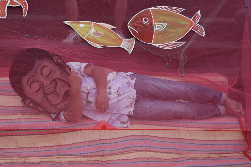 A protester wearing a mask of Philippine President Rodrigo Duterte pretends to sleep under a mosquito net to symbolise his inaction on the disputed South China Sea issues as they hold a rally outside the Chinese consulate in Metro Manila, Philippines, on May 7. Photo: AP