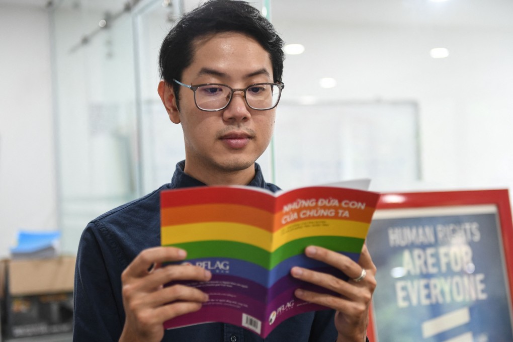 Luong The Huy, the first openly gay candidate for Vietnam‘s National Assembly, poses with a book about LGBT issues in his office in Hanoi. Photo: AFP