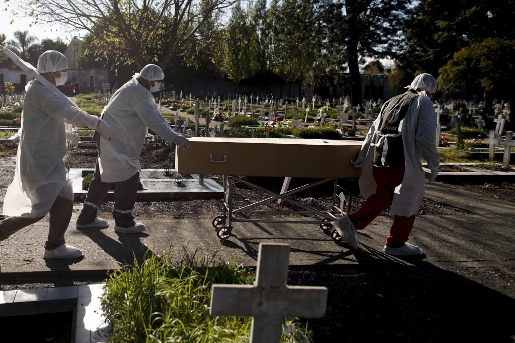 Workers push the coffin of a Covid-19 victim at a cemetery in Buenos Aires, Argentina. Photo: AP