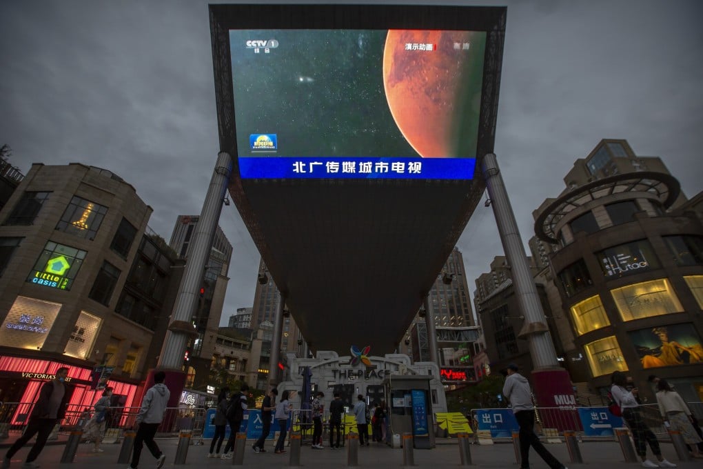 A broadcast of a news report about the successful landing of a probe on Mars is shown on a large video screen at a shopping centre in Beijing on May 15. Photo: AP
