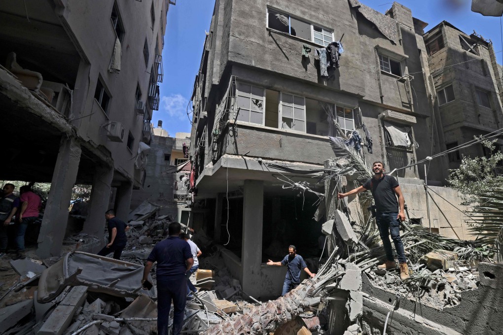 Palestinians inspect buildings damaged during Israeli air strikes in Gaza on May 20. Photo: AFP
