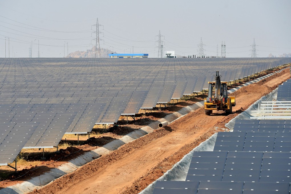 An earth mover passes between rows of solar panels at the 2,000 megawatt Shakti Sthala solar power park in Pavagada Taluk, about 150km from Bangalore, India, on March 1, 2018. Photo: AFP