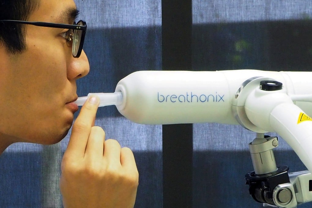 A staff member demonstrates the Breathonix breathalyser test kit. Photo: Reuters