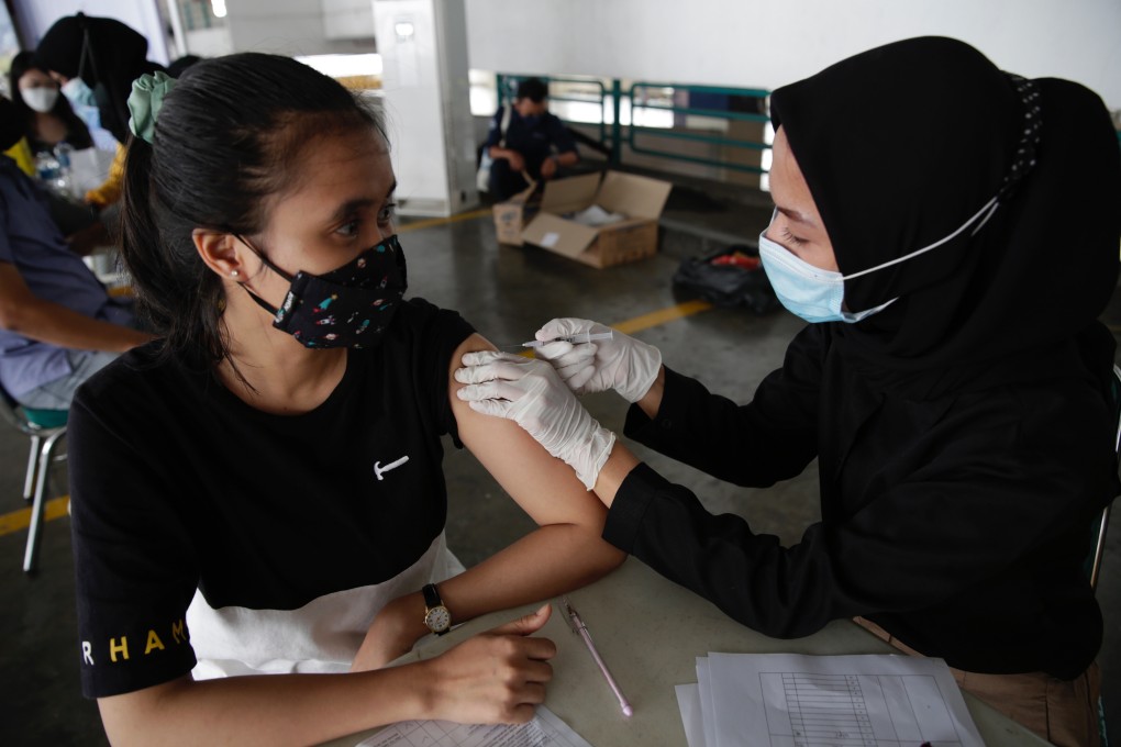 A woman receives a Covid-19 vaccine at a shopping mall in Jakarta, Indonesia. Photo: EPA