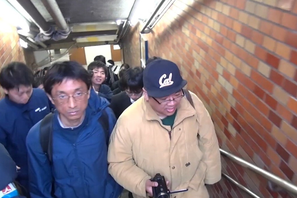Aleph member Hiroshi Araki (left) and filmmaker Atsushi Sakahara at the Tokyo Sarin Gas Attack Memorial, in 2016, in a still from Me and the Cult Leader (category: 1, Japanese), directed by Atsushi Sakahara.