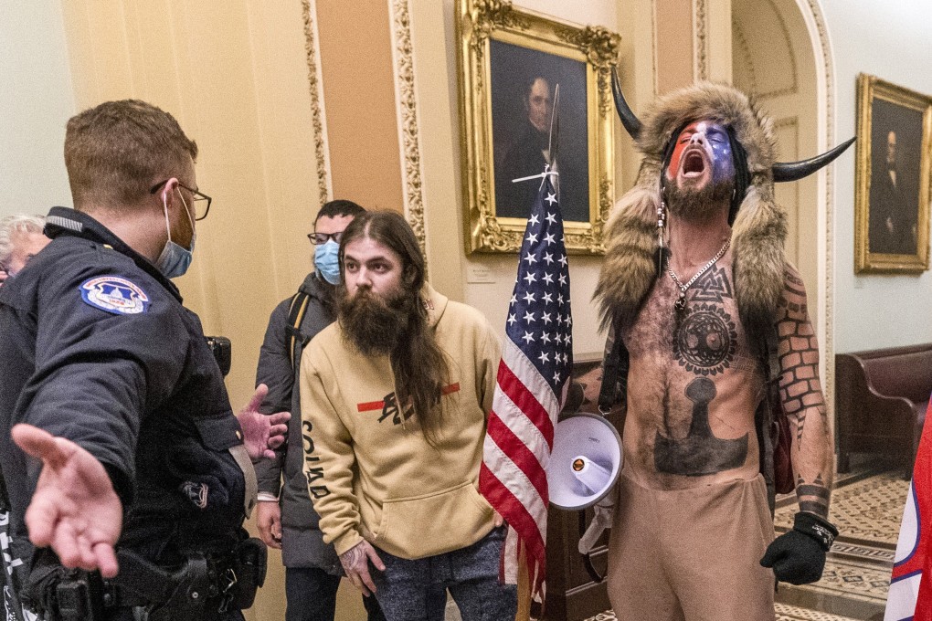 Supporters of then-US president Donald Trump, including Jacob Chansley (right), are confronted by a US Capitol Police officer outside the Senate Chamber inside the Capitol in Washington on January 6. Photo: AP
