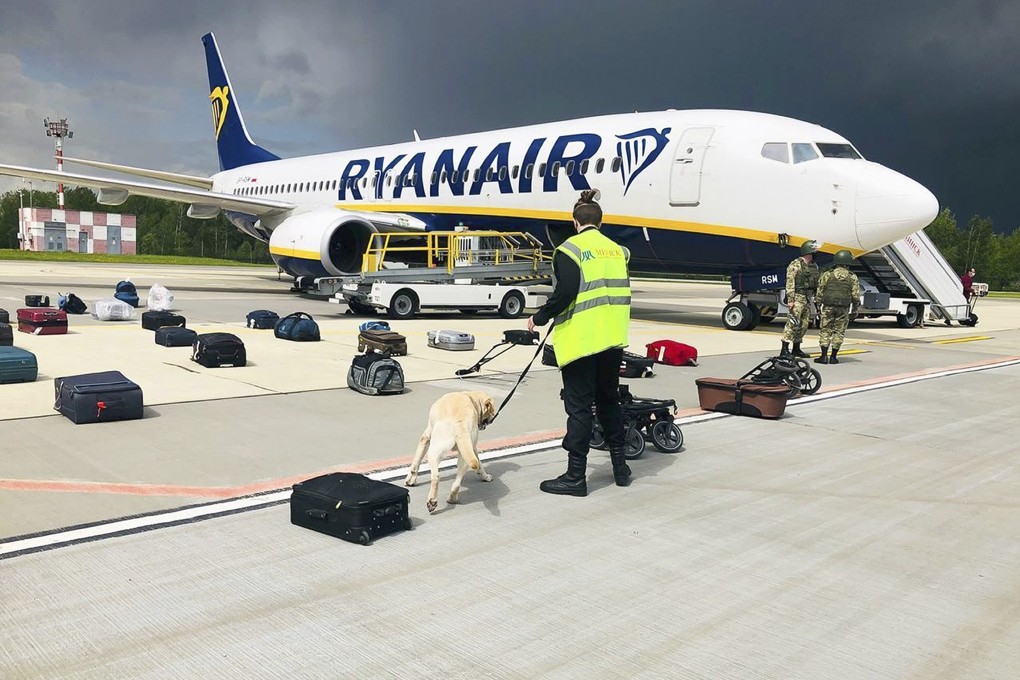 Security staff use a sniffer dog to check the luggage of passengers on the Ryanair plane carrying opposition figure Roman Protasevich at Minsk International airport on Sunday. Photo: AP