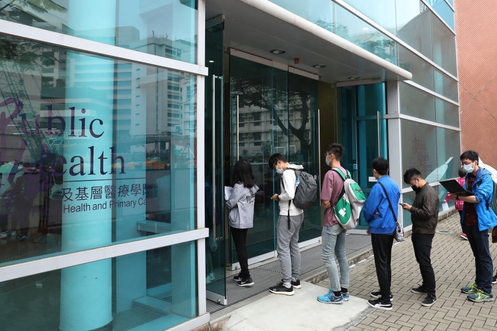 Hong Kong medical students queue to have their temperature checked before sitting an exam at the School of Public Health in Prince of Wales Hospital in Sha Tin on April 3, 2020. Photo: Nora Tam