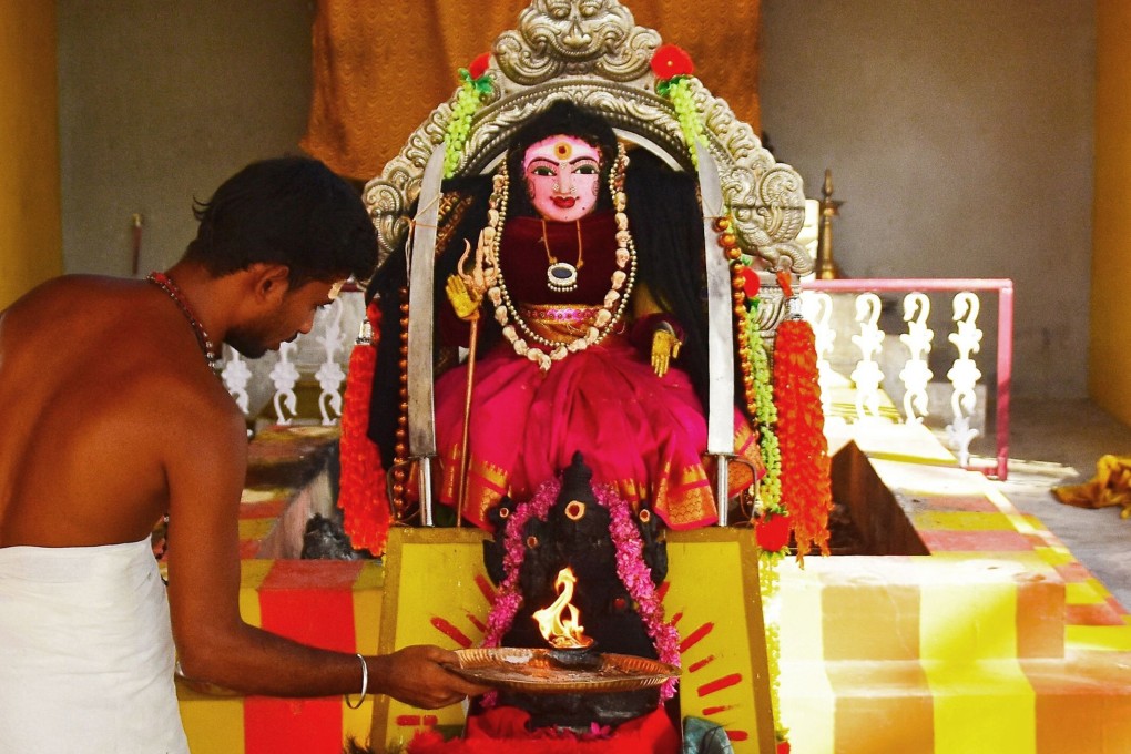 A Hindu priest performs a prayer ritual in front of an idol locally known as ‘Corona Devi’ in Coimbatore, Tamil Nadu. Photo: AFP