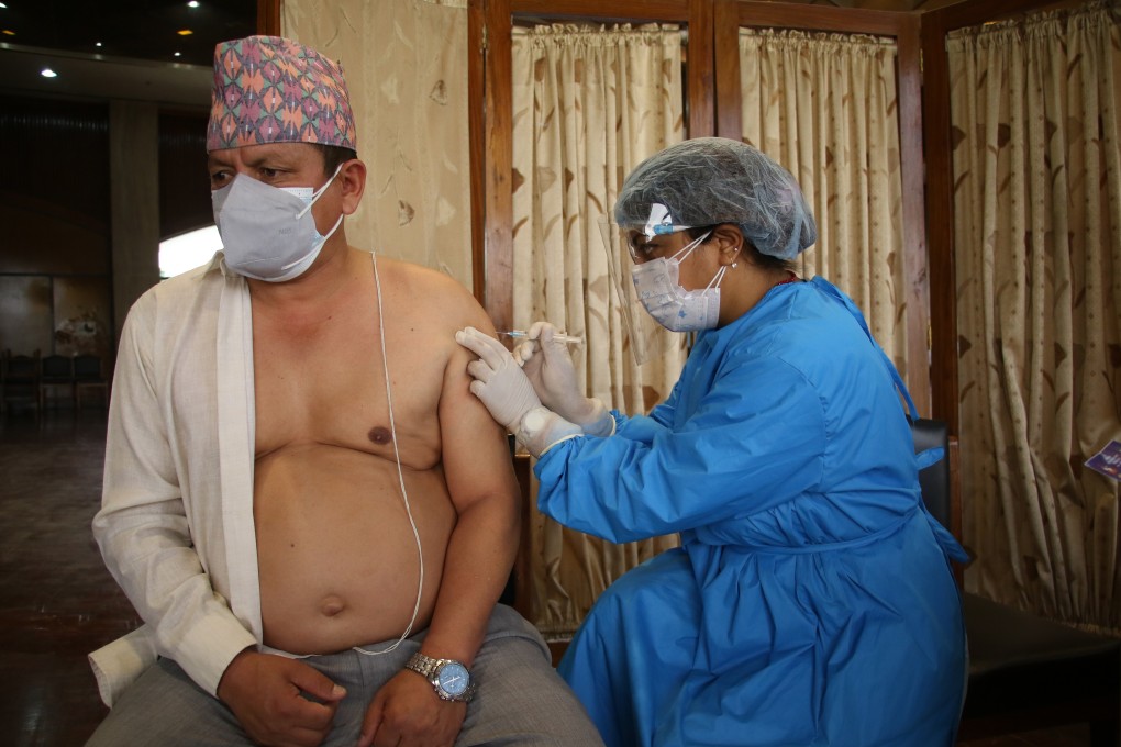 A health worker vaccinates a man in Kathmandu. Photo: Zuma Wire/ DPA