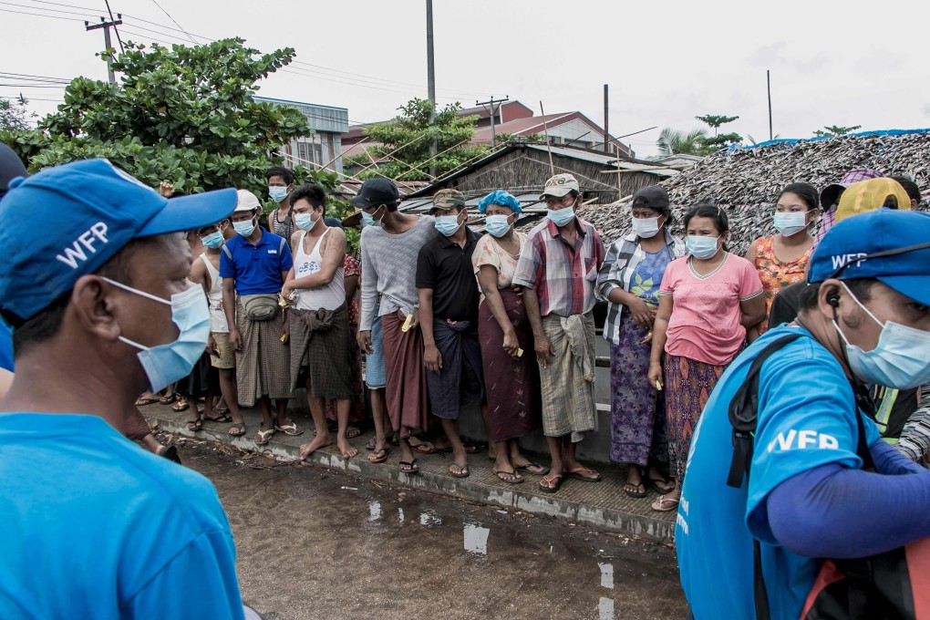 Residents on the outskirts of Yangon wait in line to receive bags of rice distributed by the World Food Programme. Photo: AFP