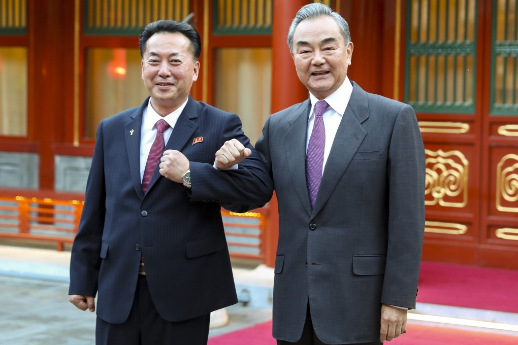 North Korean ambassador to China Ri Ryong-nam (left) and Chinese Foreign Minister Wang Yi link arms in Beijing on Thursday. Wang reaffirmed Beijing’s commitment to “traditional friendship” with the North. Photo: Xinhua