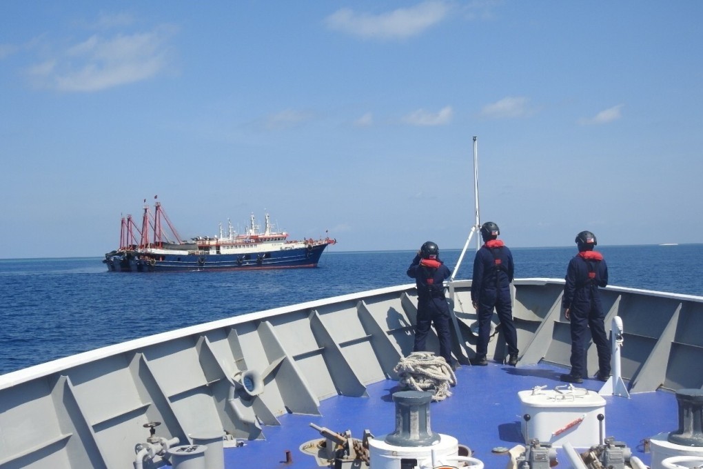 Philippine coastguard personnel survey Chinese ships in Sabina Shoal. Photo: Reuters
