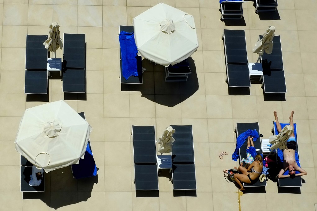 People lounge at the pool of a hotel in the resort town of Ayia Napa in Cyprus. Photo: AP
