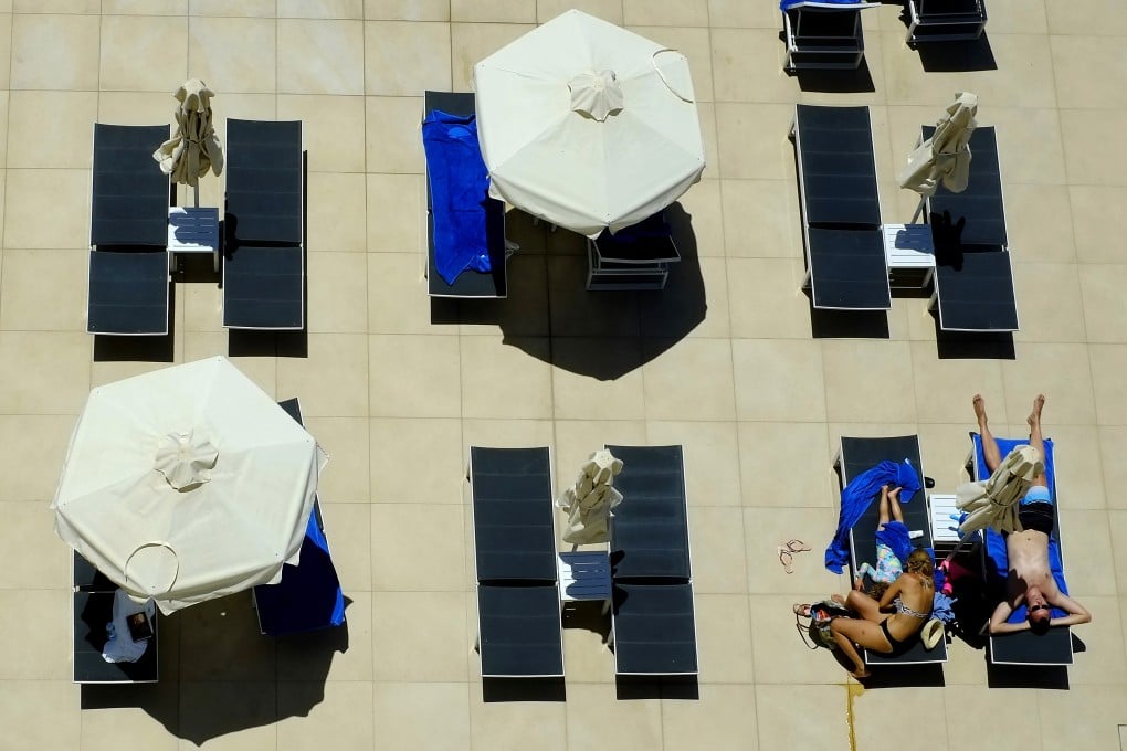 People lounge at the pool of a hotel in the resort town of Ayia Napa in Cyprus. Photo: AP