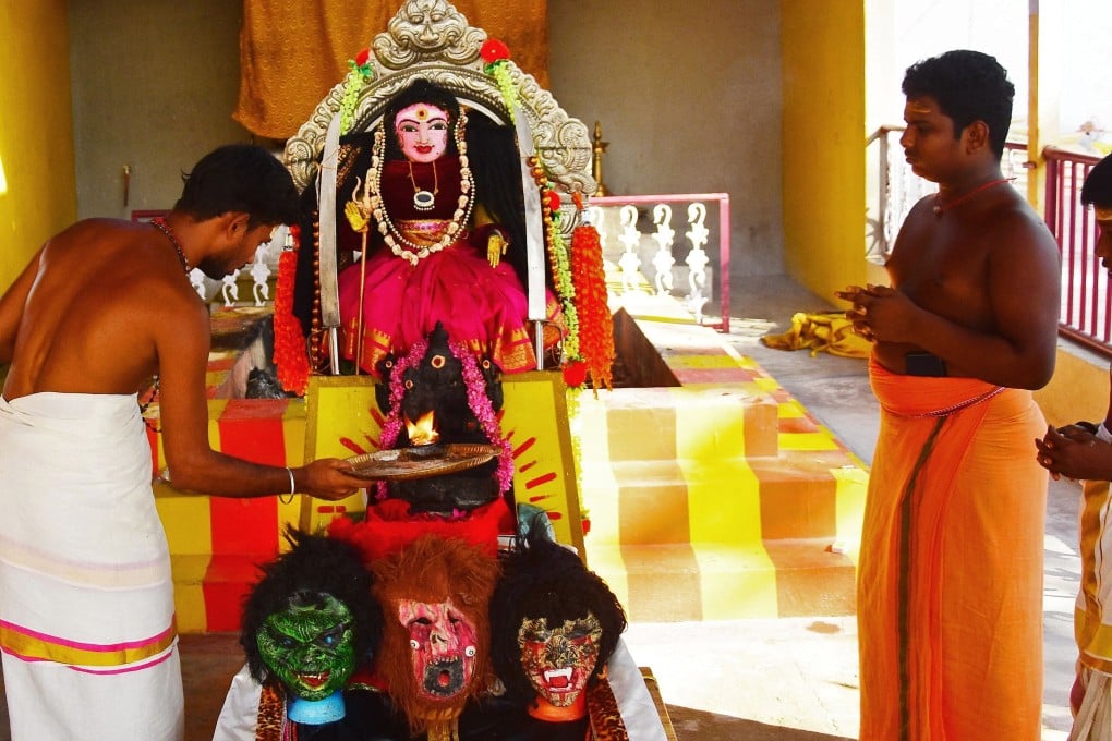 A priest performs a prayer ritual in front of an idol known locally as ‘Corona Devi’, believed to safeguard people from the coronavirus, at Kamatchipuri Adhinam Temple in Coimbatore. Photo: AFP
