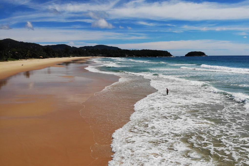 A man walks along an unusually quiet Karon beach in Phuket on September 30, 2020. Photo: AFP