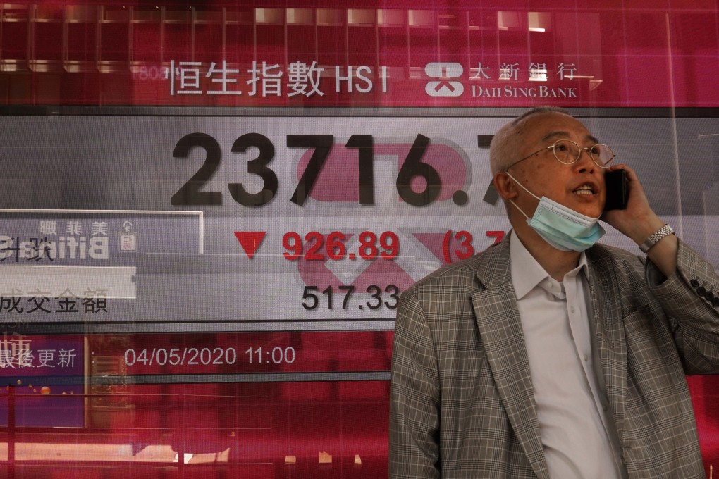 A man stops next to an electronic board showing the Hong Kong share index on May 4, 2020. Photo: AP