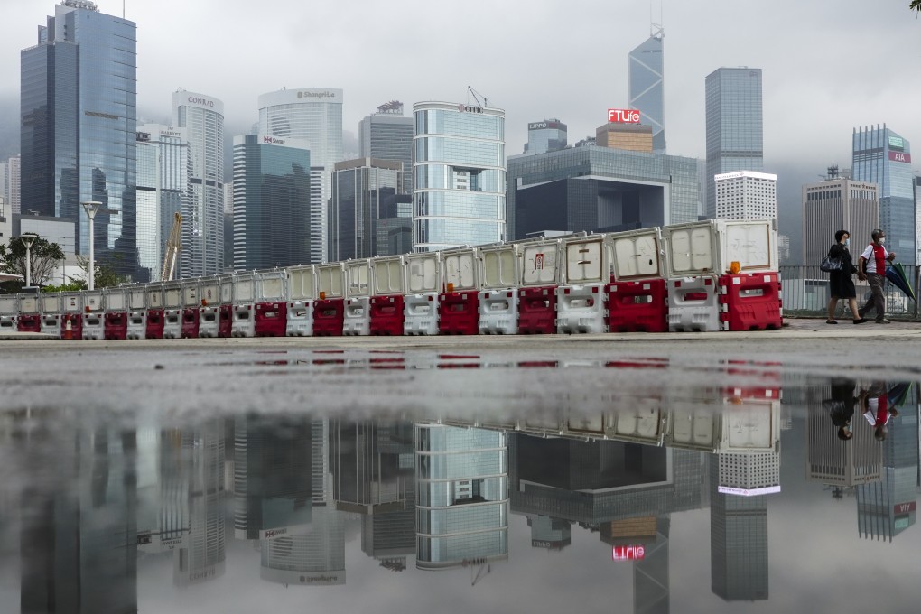 Hong Kong’s Central business district forms the backdrop for people walking along the Wan Chai waterfront on May 3. Photo: Robert Ng
