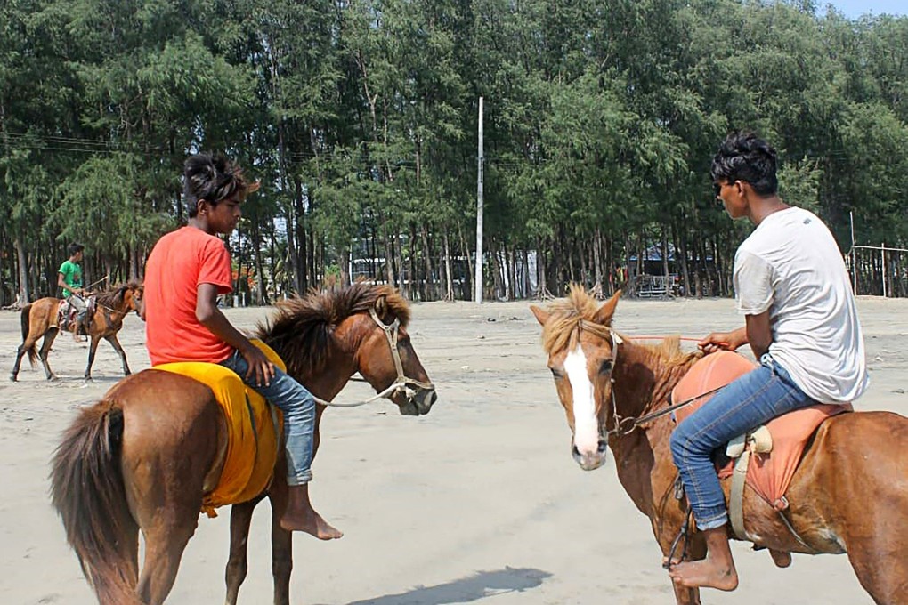 Youths wait for customers to ride on their horses at Cox’s Bazar Beach, Bangladesh, on May 29, where at least 21 horses out of up to 90 used for tourists at the beach have died over the past month. Photo: AFP