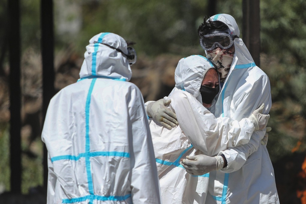 A relative of a person who died of Covid-19 is consoled by another during cremation in Jammu, India. File photo: AP