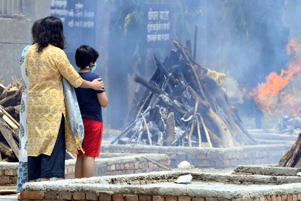 A family looks at the funeral pyres for a Covid-19 victim in New Delhi. Photo: Xinhua