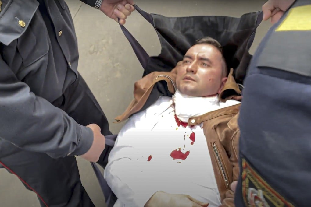 Police officers carry activist Stsiapan Latypau to an ambulance after he stabbed himself with a pen in court in Minsk, Belarus on Tuesday. Photo: Radio Free Europe/Radio Liberty via AP