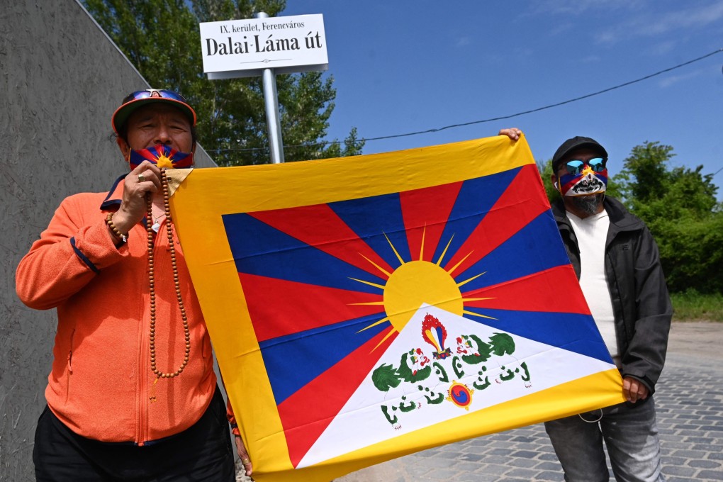 Activists hold the Tibetan flag underneath a street sign reading “Dalai Lama Road” in Budapest, Hungary. Photo: AFP