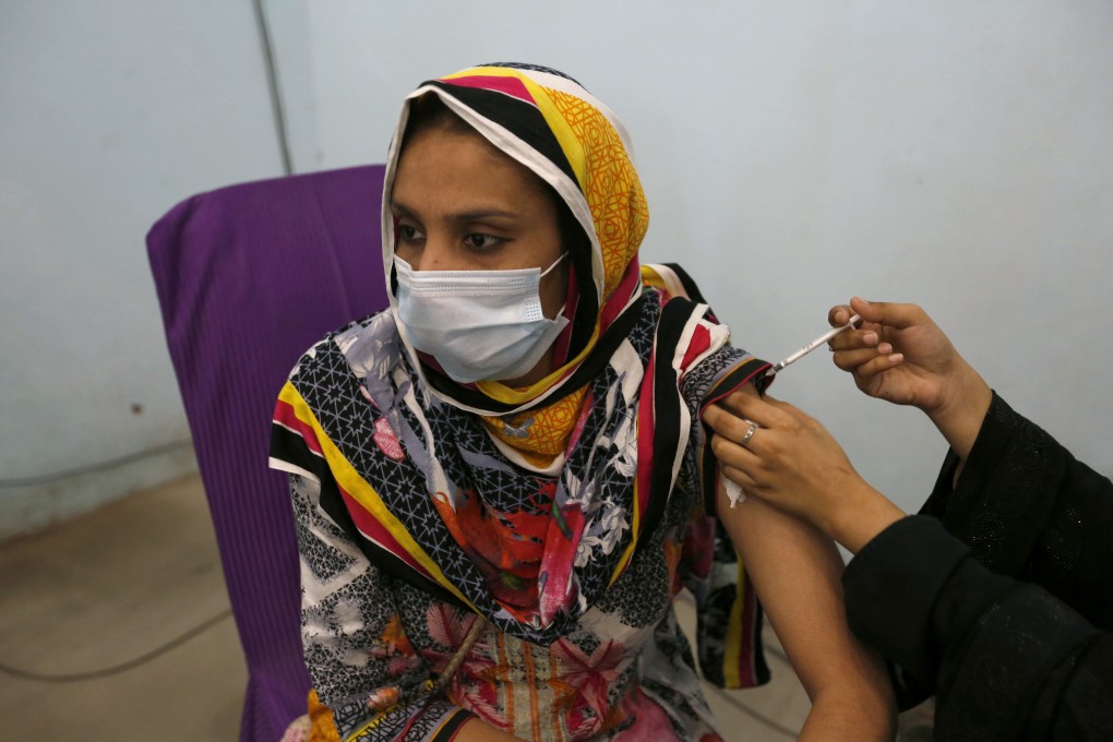 A woman receives the first shot of the Sinovac Covid-19 vaccine from a paramedic at a vaccination centre in Lahore, Pakistan, on Thursday. Photo: AP