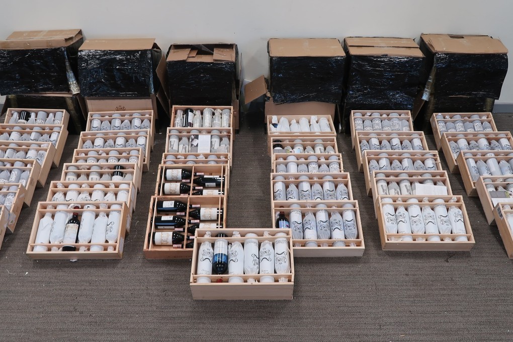 Customs officials display bottles of high-end French wine seized in an anti-smuggling operation on Lantau Island. Photo: Handout
