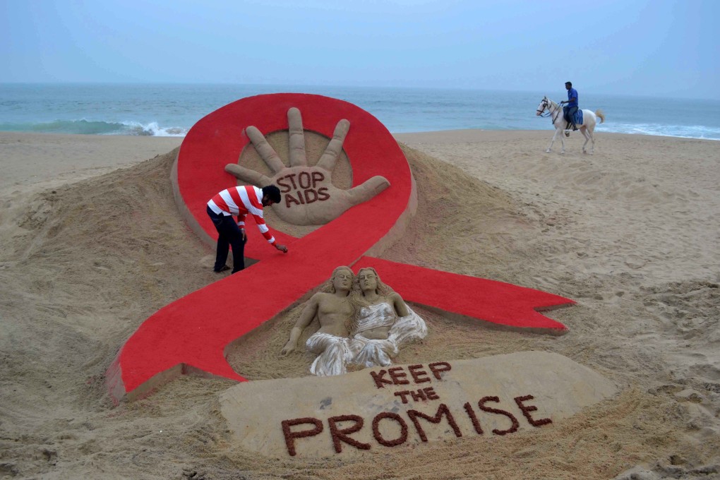 Sand artist Sudersan Pattnaik puts the final touches to a sand sculpture on the eve of World Aids Day on Golden Sea Beach in Puri, India, on November 29, 2013. Photo: AFP
