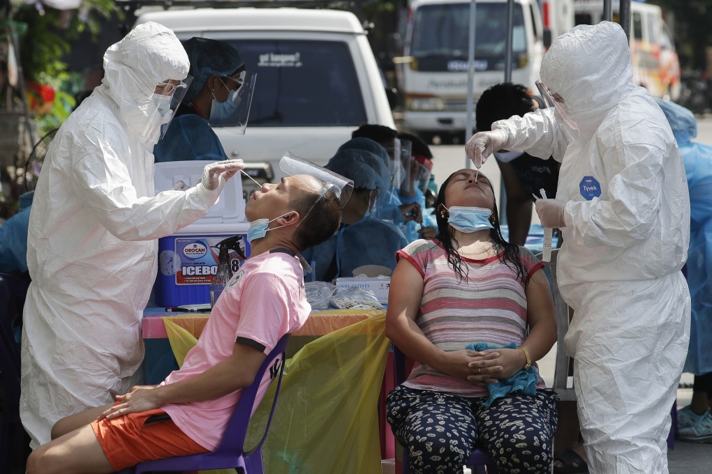 Health workers conduct a Covid-19 swab test on residents in Quezon City, Philippines. Photo: AP